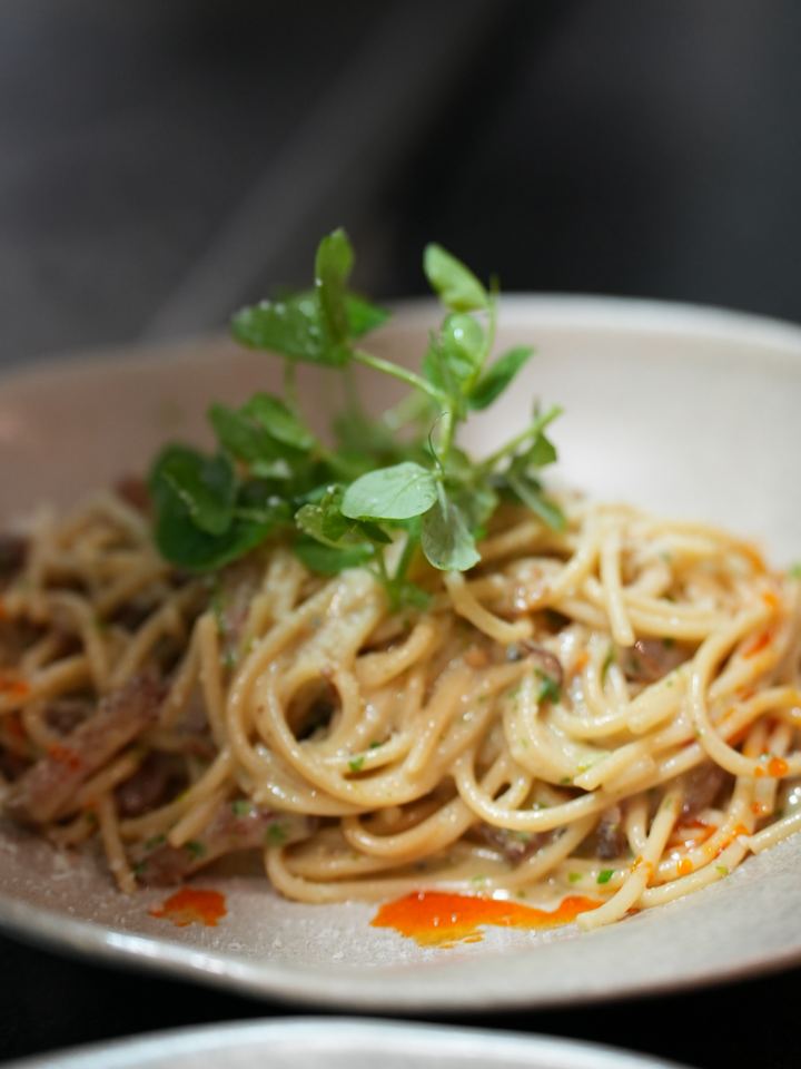 Spaghetti carbonara finished with pea shoots